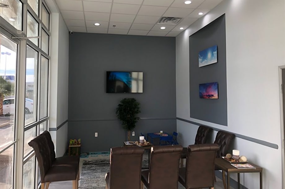 Modern dental office waiting room with comfortable seating and contemporary wall art.